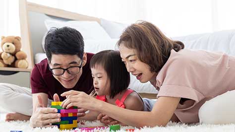 Family playing with toys with young child