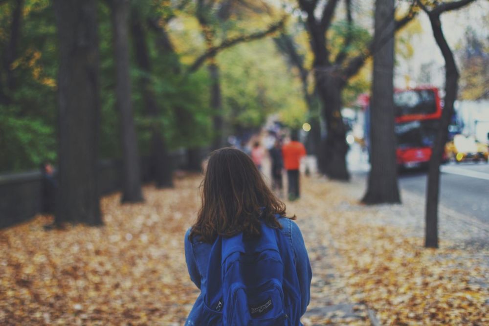 A child walking to school with a backpack on their back