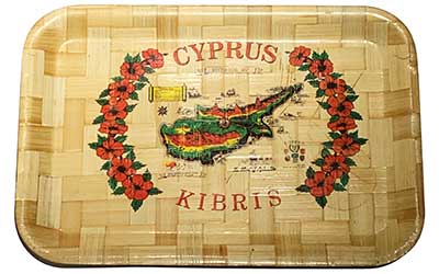 This type of wooden tray can be found in many Cypriot households both domestically and internationally. It shows a map of Cyprus with key historical dates and locations. Photo credit: Tina Plevriti