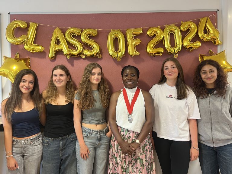 Students standing under a 'Class of 2024' banner