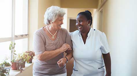A nurse and an older person smiling
